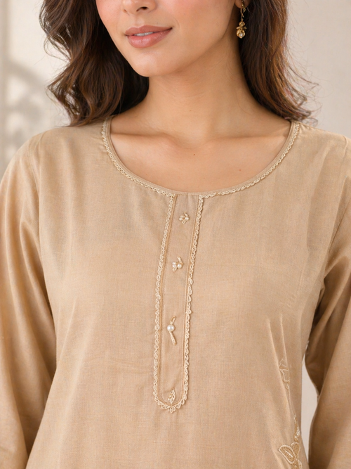 Close-up of embroidered neckline on beige kurta featuring delicate thread work and button detailing