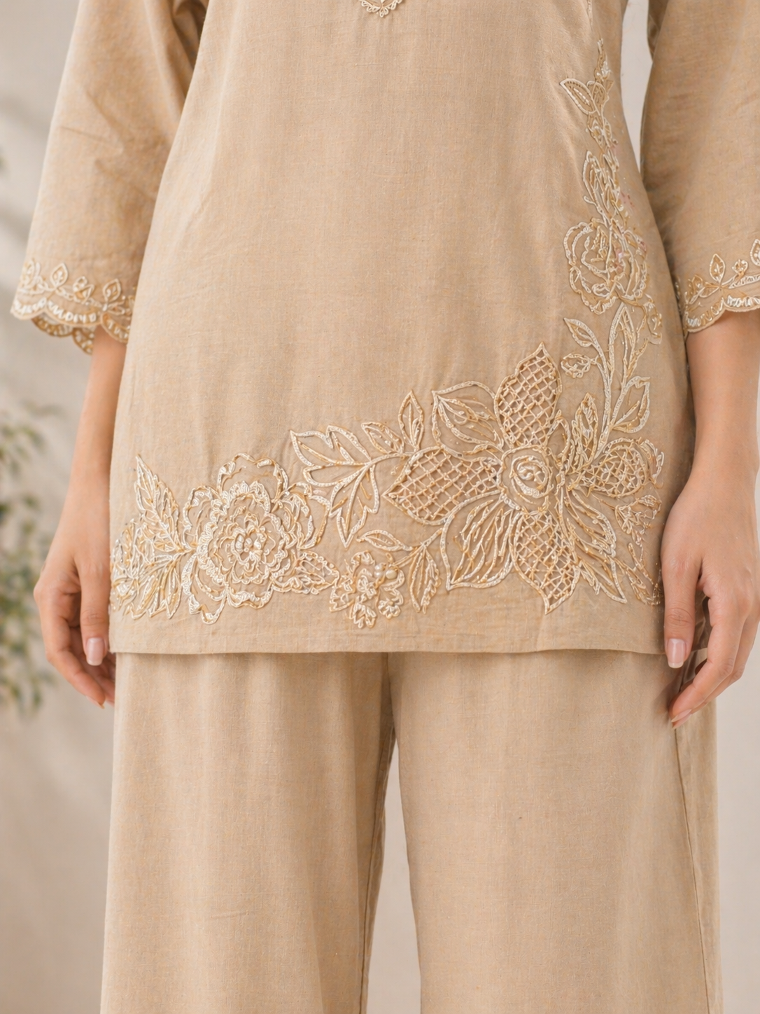 Detailed floral embroidery on hem of beige kurta showcasing intricate thread design and craftsmanship