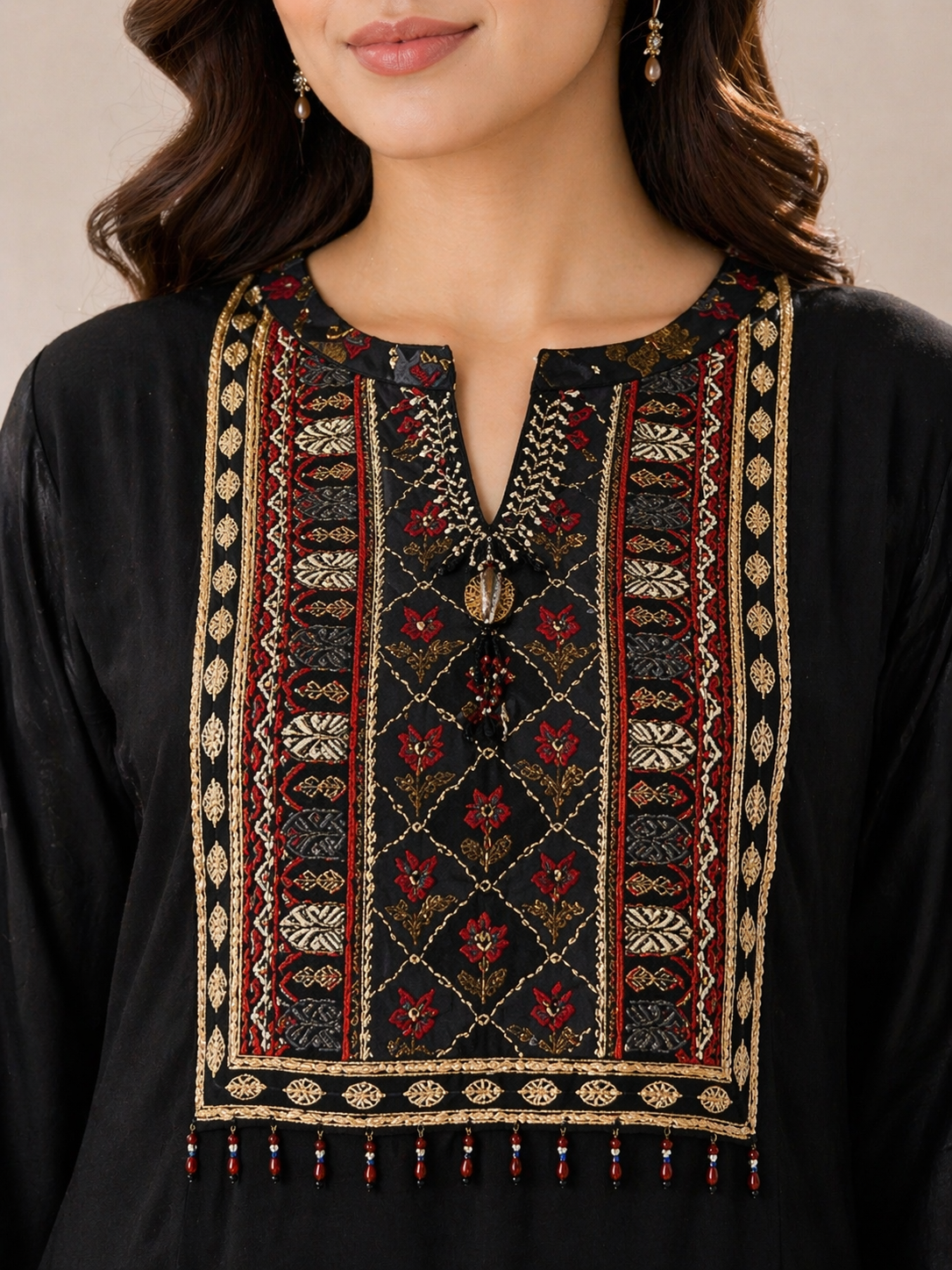 Close-up of black kurta neckline with red and gold embroidery detailing